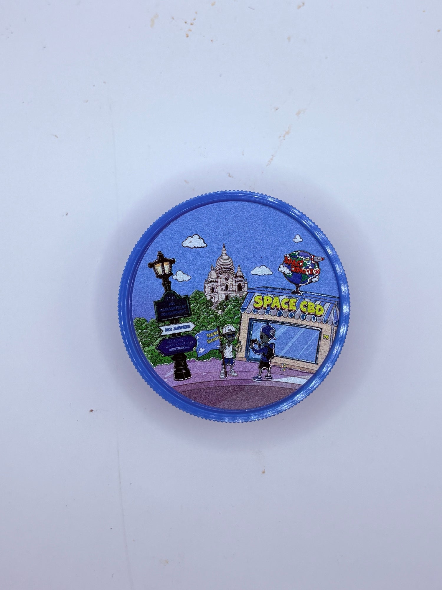 Grinder plastique bleu Space CBD Montmartre, Sacré-Cœur et façade du shop